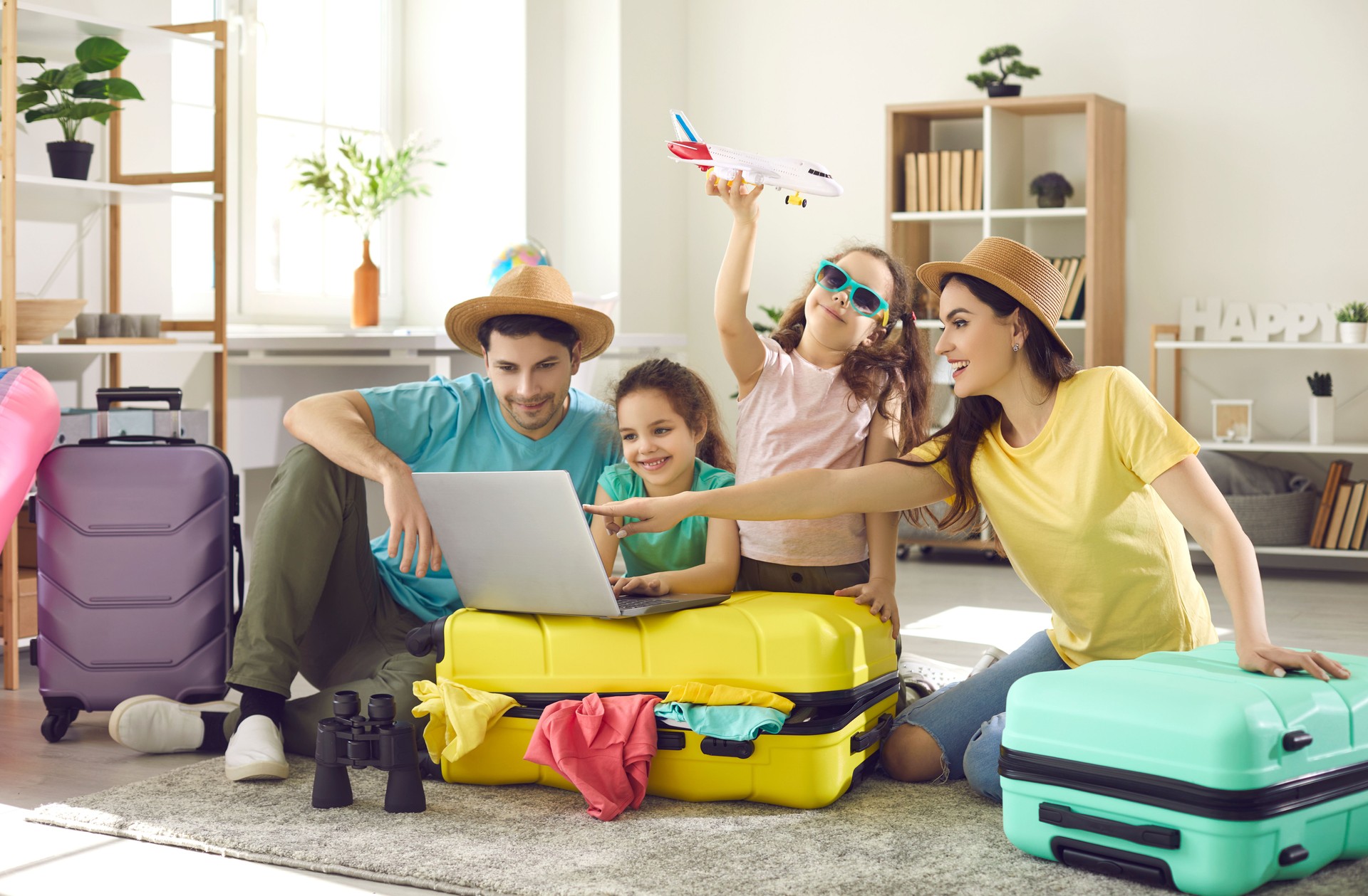 Happy family and kids with travel suitcase buying ticket booking hotel online